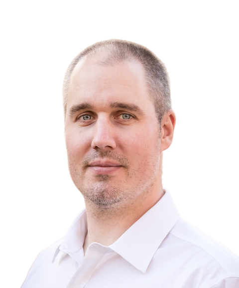 Balding man with short hair in a white shirt, looking at the camera against a white background.