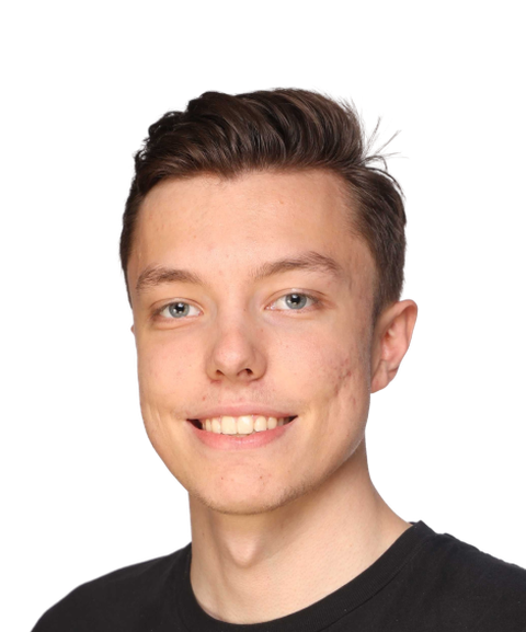 Smiling person with short brown hair wearing a black shirt, against a plain white background.