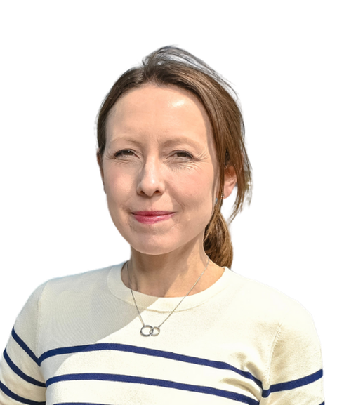 Woman with light brown hair in a ponytail, wearing a striped sweater and necklace, smiles slightly against a plain white background.
