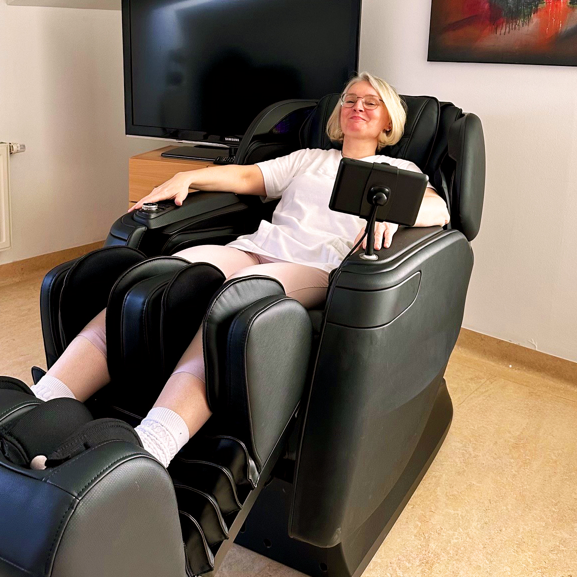 Eine Mitarbeiterin sitzt entspannt auf dem hauseigenen Massage-Sessel.