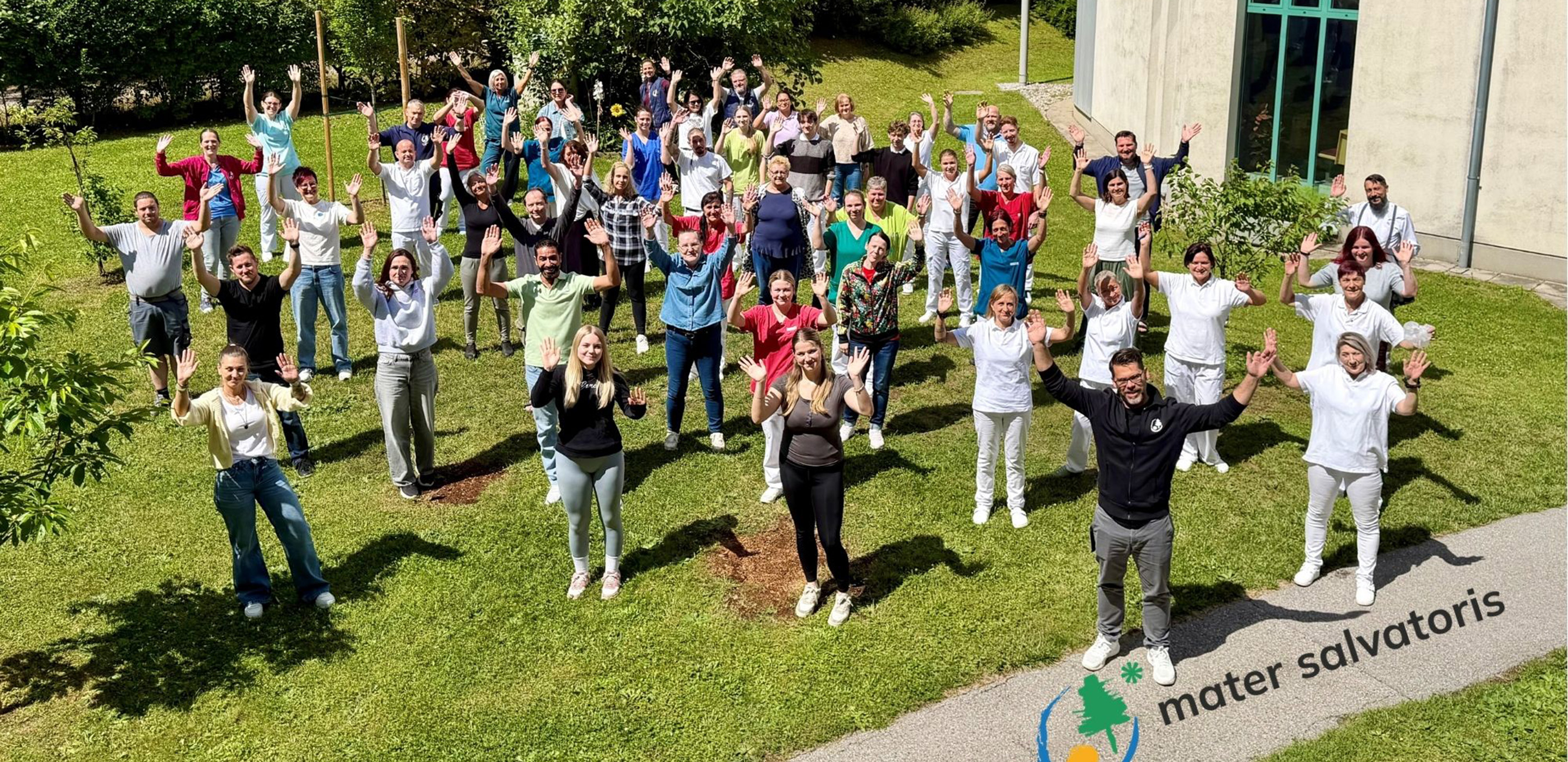 Das Team von Mater Salvatoris winkend im Garten