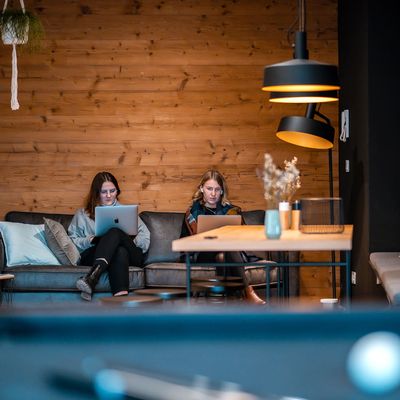 Gemütliche Bürolounge mit zwei Personen die arbeiten