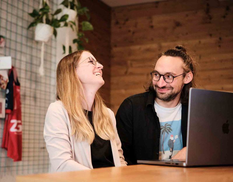 Mann und Frau sitzen an einem Tisch und schauen sich an.