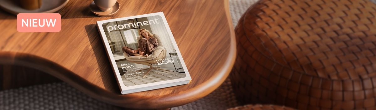 A magazine titled "Prominent" featuring a woman lounging in a cozy setting on a wooden table alongside a woven pouf and cup.
