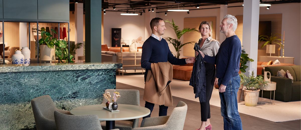 medewerker neemt jassen aan van klanten