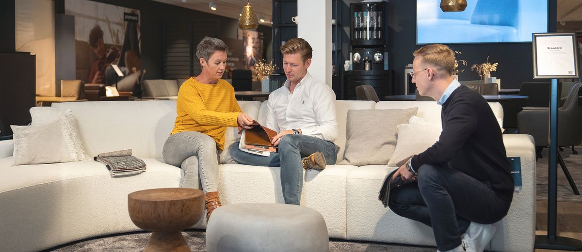 klanten kijken en voelen verschillende leerstoffen, medewerker helpt met kiezen algemeen header