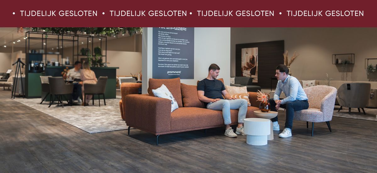 Twee mannen zitten op banken in een modern ingerichte ruimte met een bord dat 'Tijdelijk Gesloten' aangeeft bovenaan de foto.
