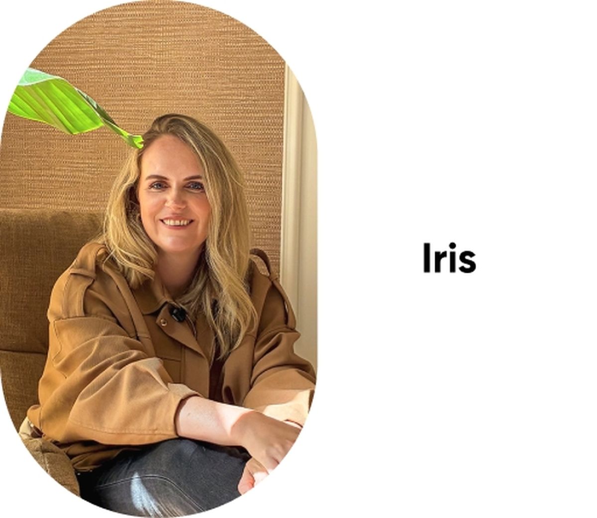 Woman with blonde hair in a brown coat sitting on a chair, smiling, with a leaf in the background. The text "Iris" is to the right.