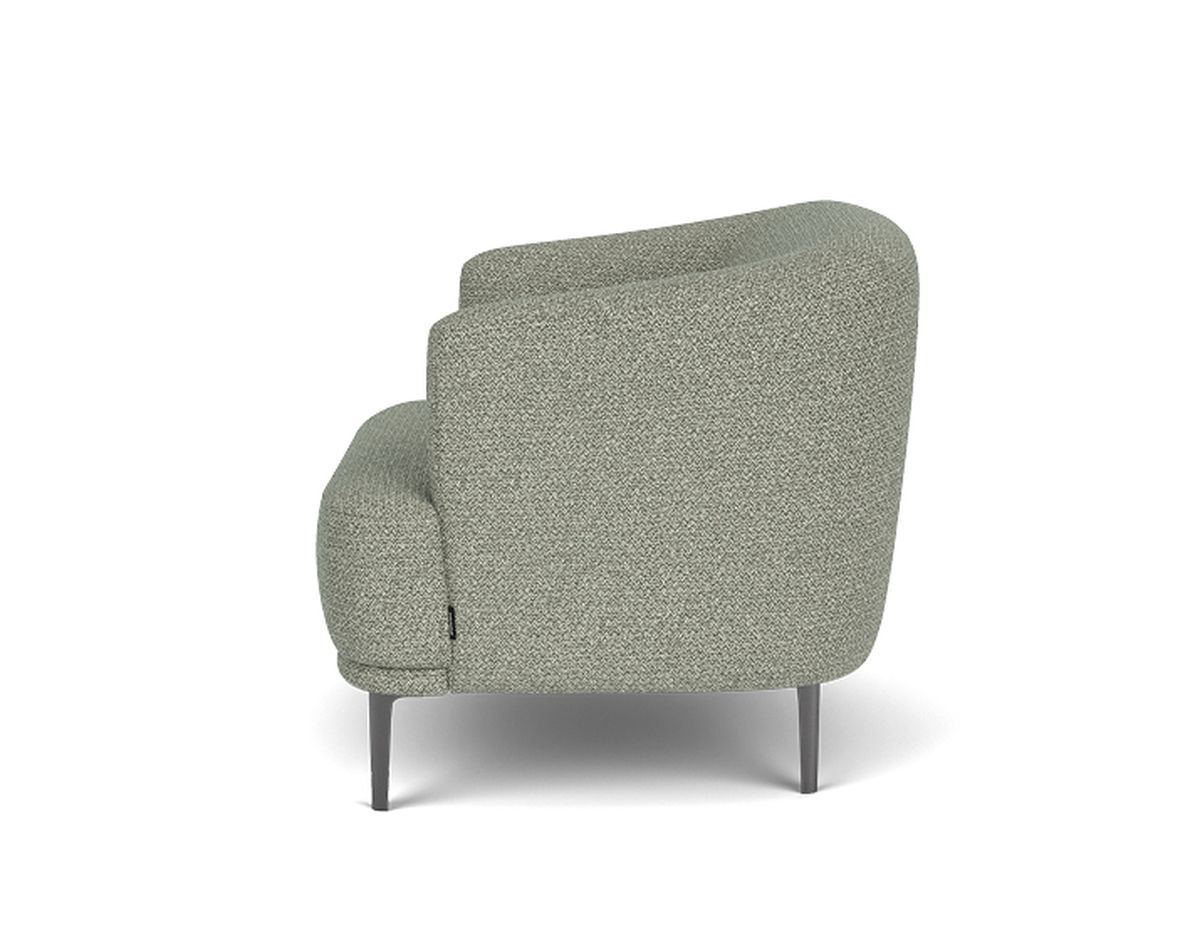 Side view of a modern, light gray upholstered armchair with curved back and metal legs against a white background.