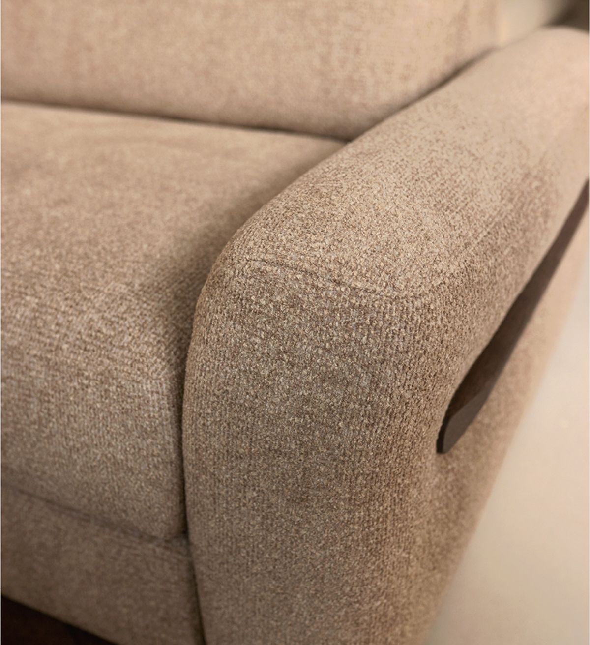 Close-up of a brown textured fabric sofa armrest with a smooth finish, highlighting its solid construction and subtle design details.