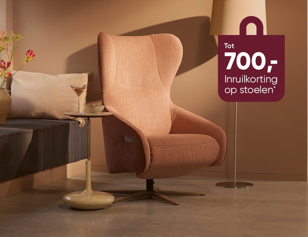 Cozy pink armchair with a floor lamp, side table holding a drink, and flowers. Brown wall with text promoting a discount on chairs.