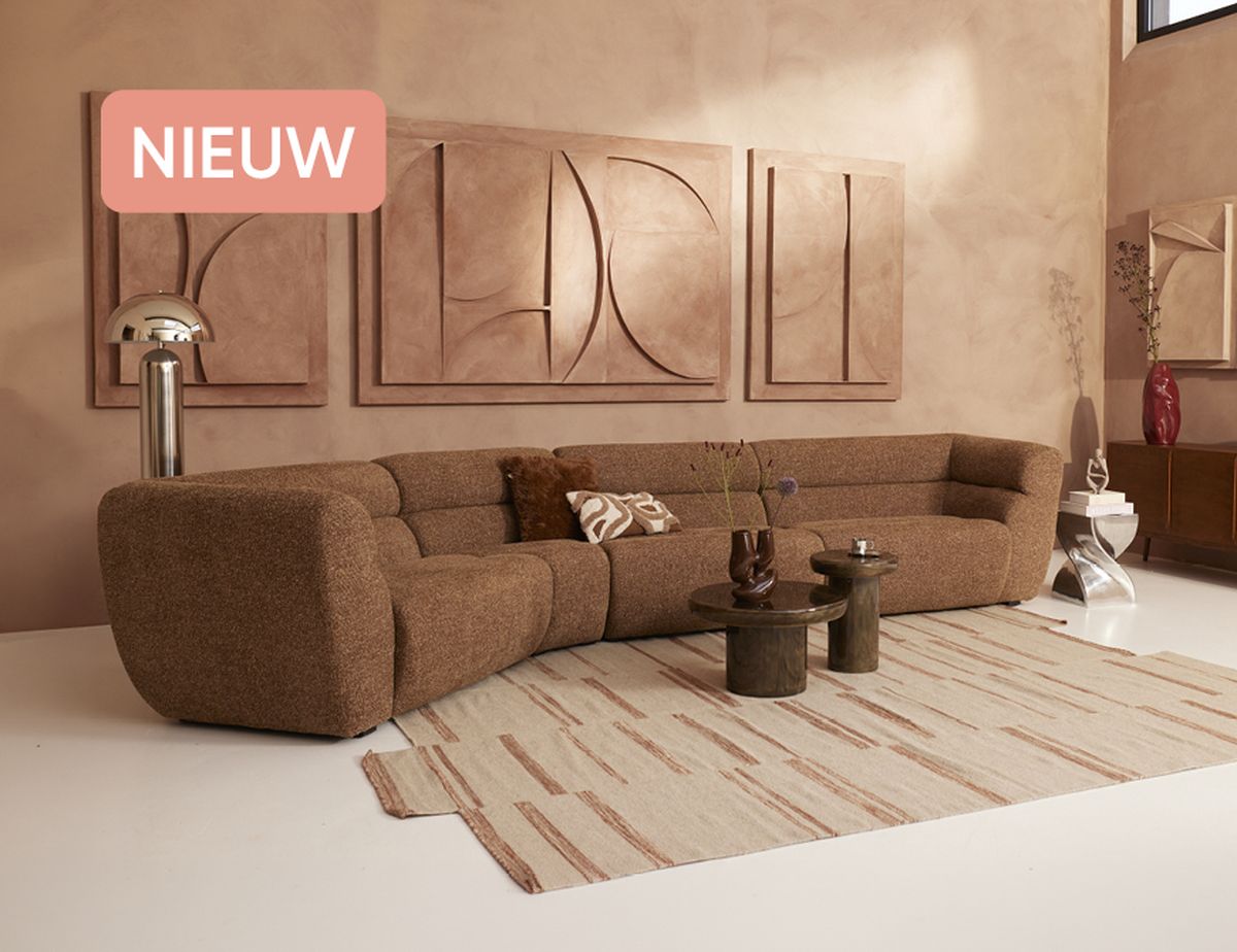 Modern living room with brown sectional sofa, abstract wall art, and matching decor. The floor features a beige patterned rug. Light and earthy tones.