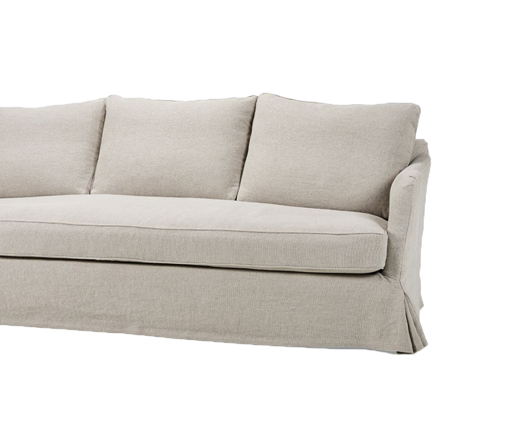 Close-up of the Lucie sofa, featuring soft, neutral-colored upholstery and three back cushions. The skirted base gives the sofa a relaxed, casual aesthetic.