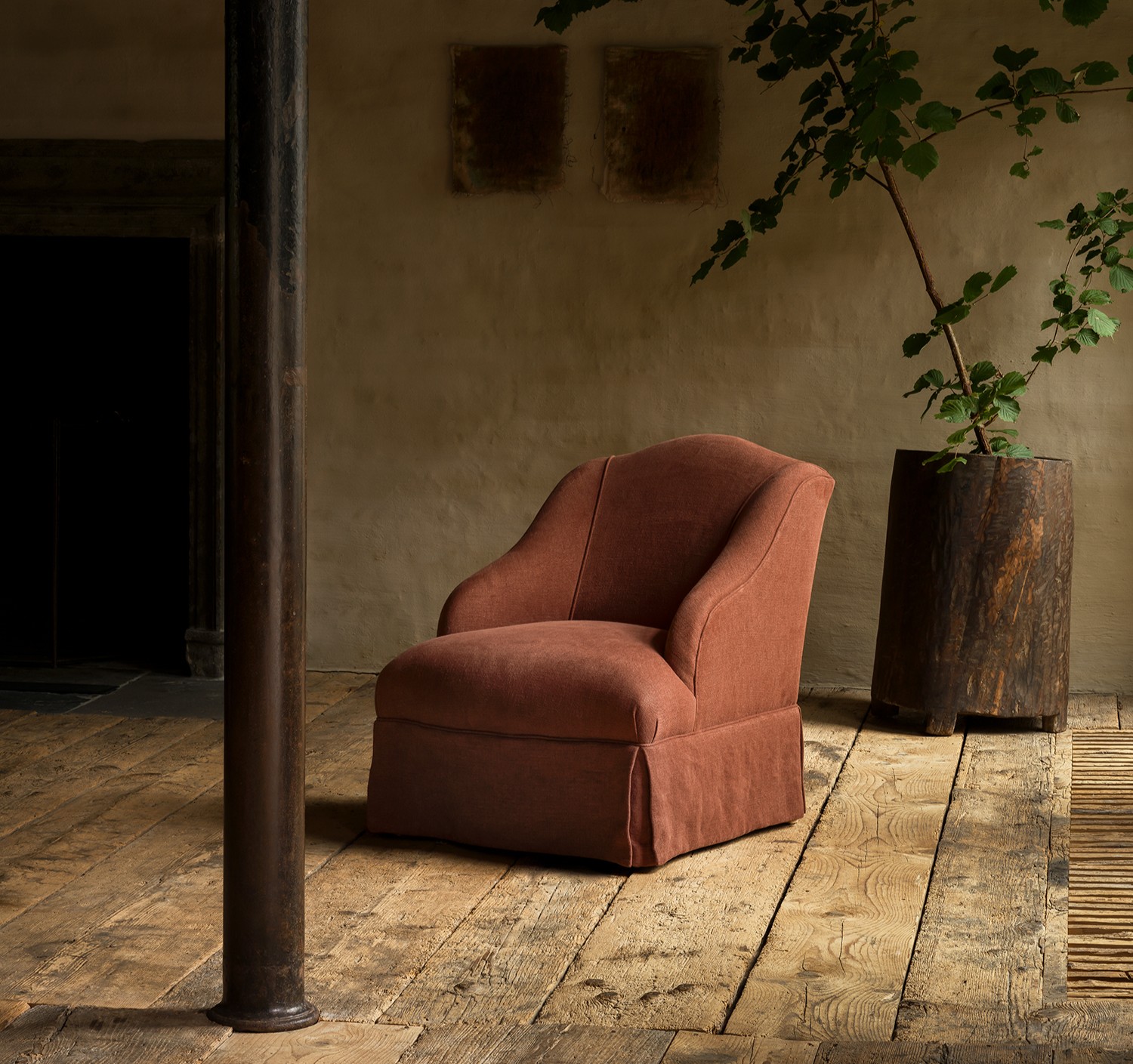 Rust-colored Kitros chauffeuse with curved backrest in a rustic wooden interior.