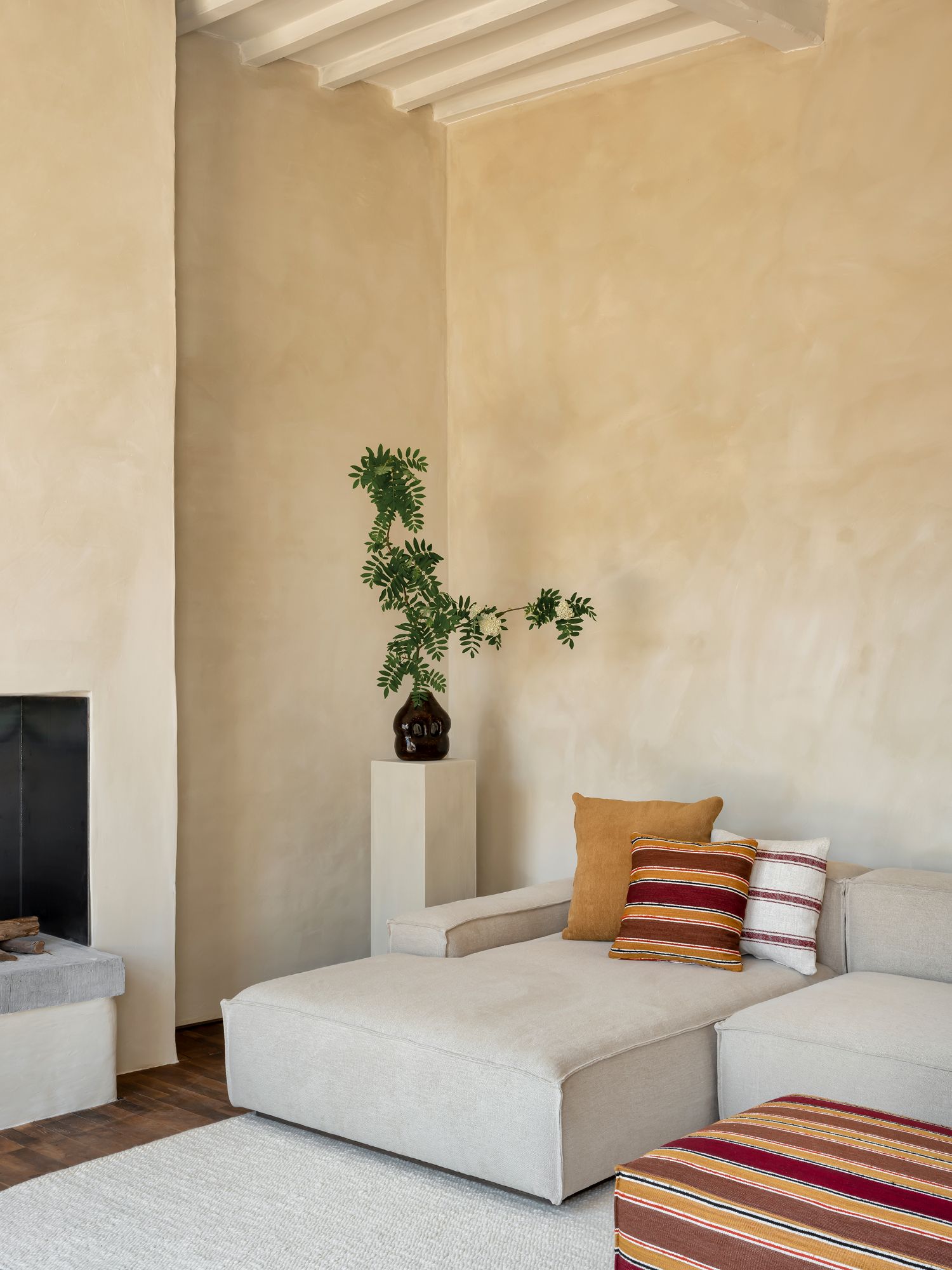 Collett & Victor Dix sofa with chaise longue and striped cushions in modern neutral interior.