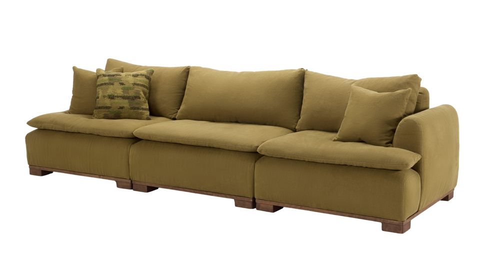 Magnus sofa in olive green fabric with loose back cushions and wooden legs, offering a spacious and relaxed design.