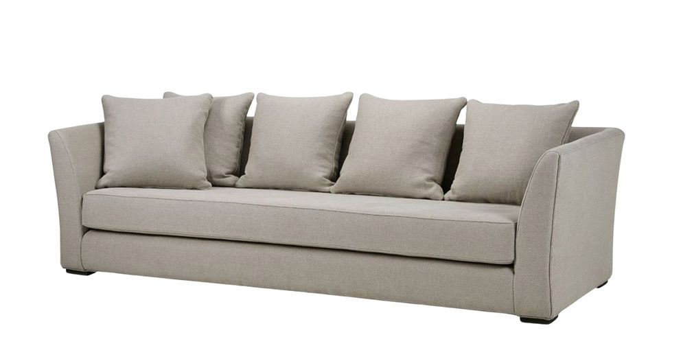 A contemporary sofa with a minimalist design, featuring five square cushions and sleek angled armrests. The upholstery is a light neutral fabric, creating a clean and modern aesthetic.