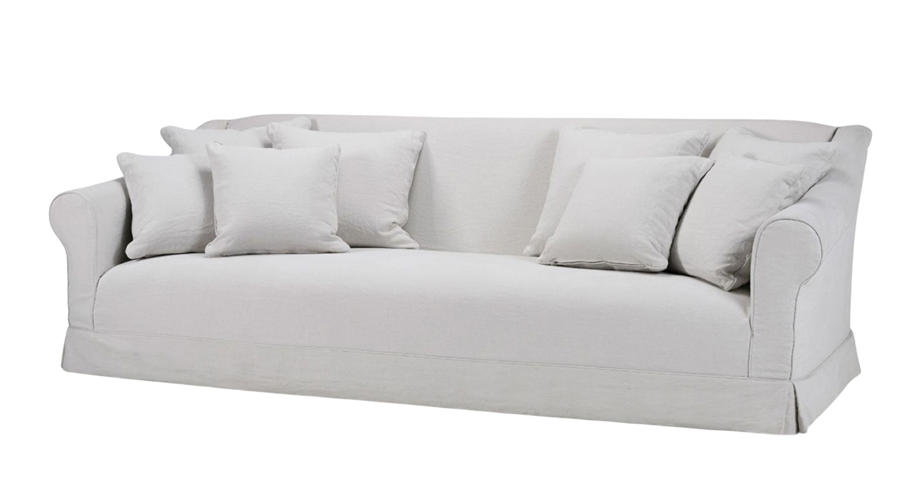 Barbara sofa in soft off-white fabric with classic rolled arms, a tailored skirt, and multiple matching scatter cushions for a relaxed, elegant look.