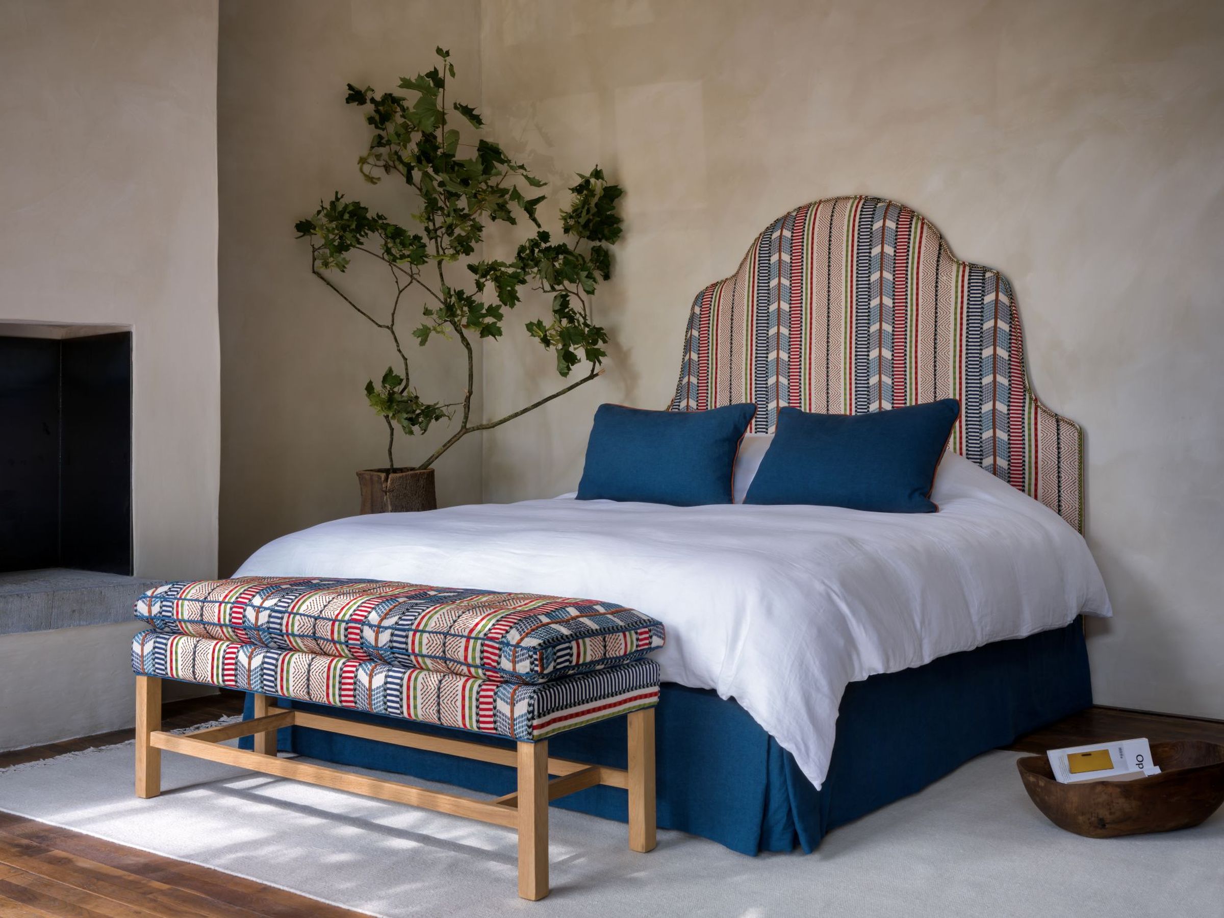 Collett & Victor bedroom with upholstered Max Bench and matching patterned headboard in colorful fabric design.