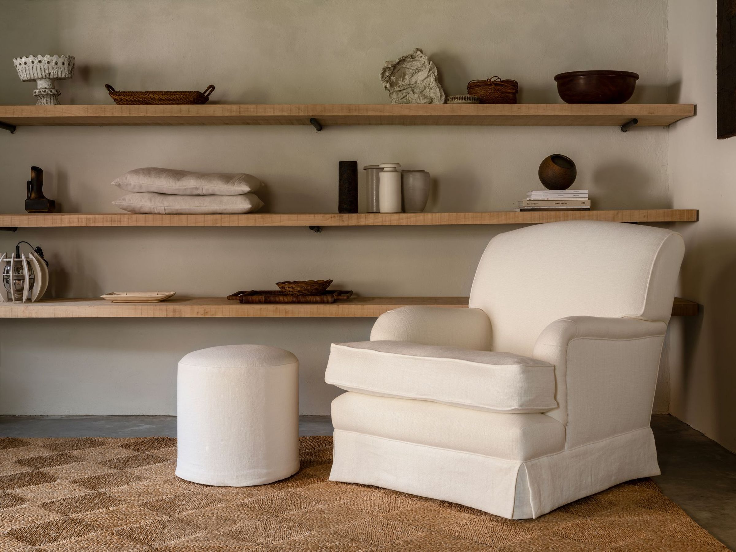 Hecto loose seat armchair in off-white linen with matching ottoman in minimalist interior