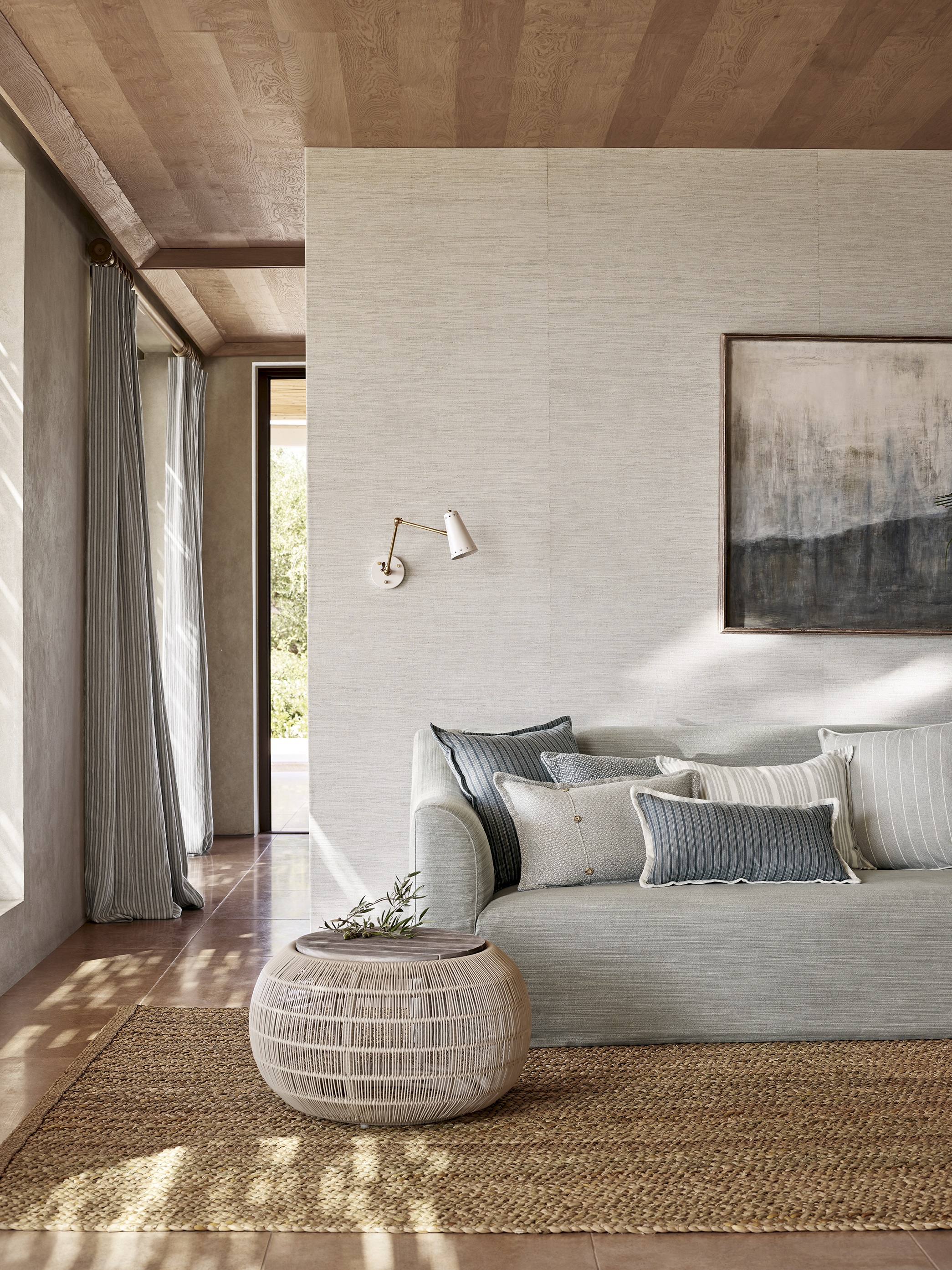 Bright living space featuring the Toscana fixed seat sofa by Collett & Victor in soft neutral upholstery, styled with striped and textured cushions, natural light, and earthy accents for a serene atmosphere.