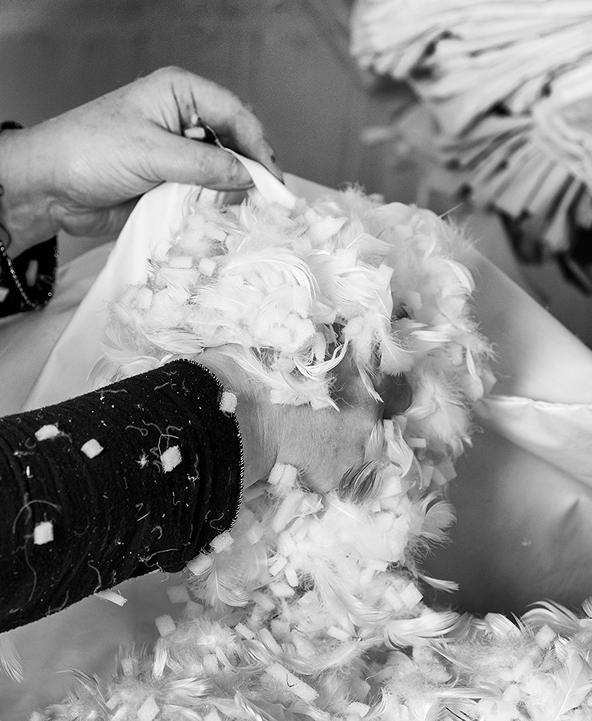 Collett & Victor artisan hand-filling cushions with natural feathers for luxury furniture.