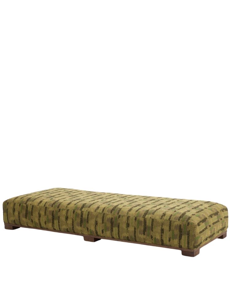 Magnus pouf in a green patterned fabric with low wooden block feet.