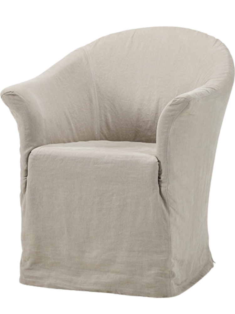 Thibaut dining chair by Collett & Victor, upholstered in light beige linen with rounded arms and a fitted slipcover design.
