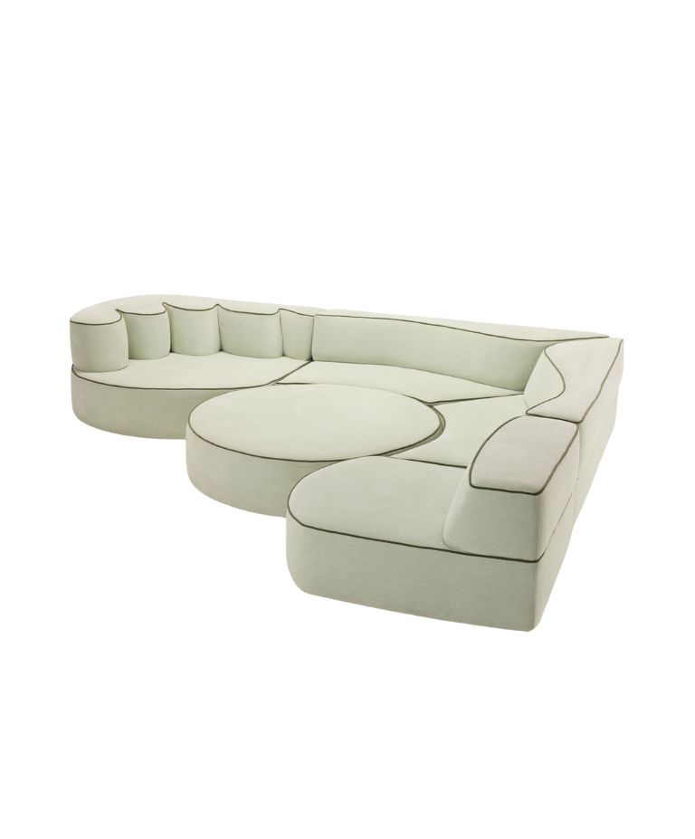 Modular Comporta sofa in pale green upholstery with dark piping, featuring organic, rounded forms and a central circular cushion element.