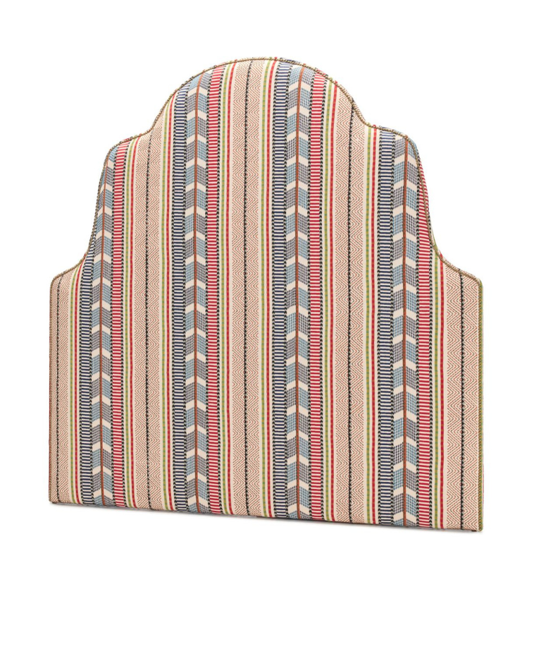 Penelope headboard by Collett & Victor upholstered in a colorful striped fabric. Features a distinctive arched top with soft curves and bold vertical pattern.