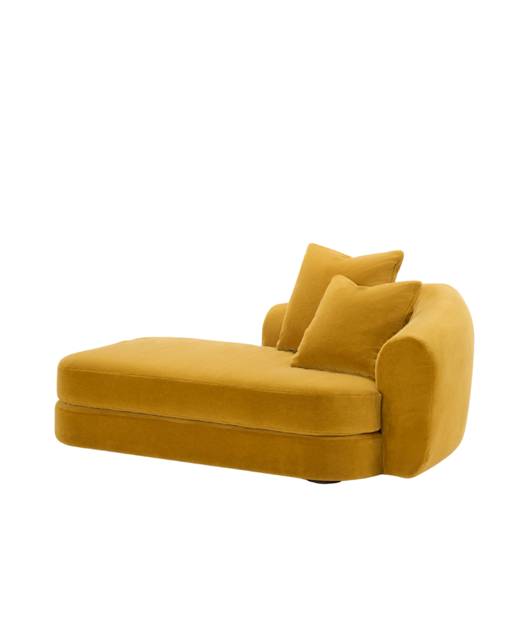 A luxurious yellow velvet chaise longue with rounded arms and soft cushions, offering a cozy and stylish seating option. The chaise longue has a modern and elegant design, featuring a smooth fabric texture and a relaxed, inviting shape.