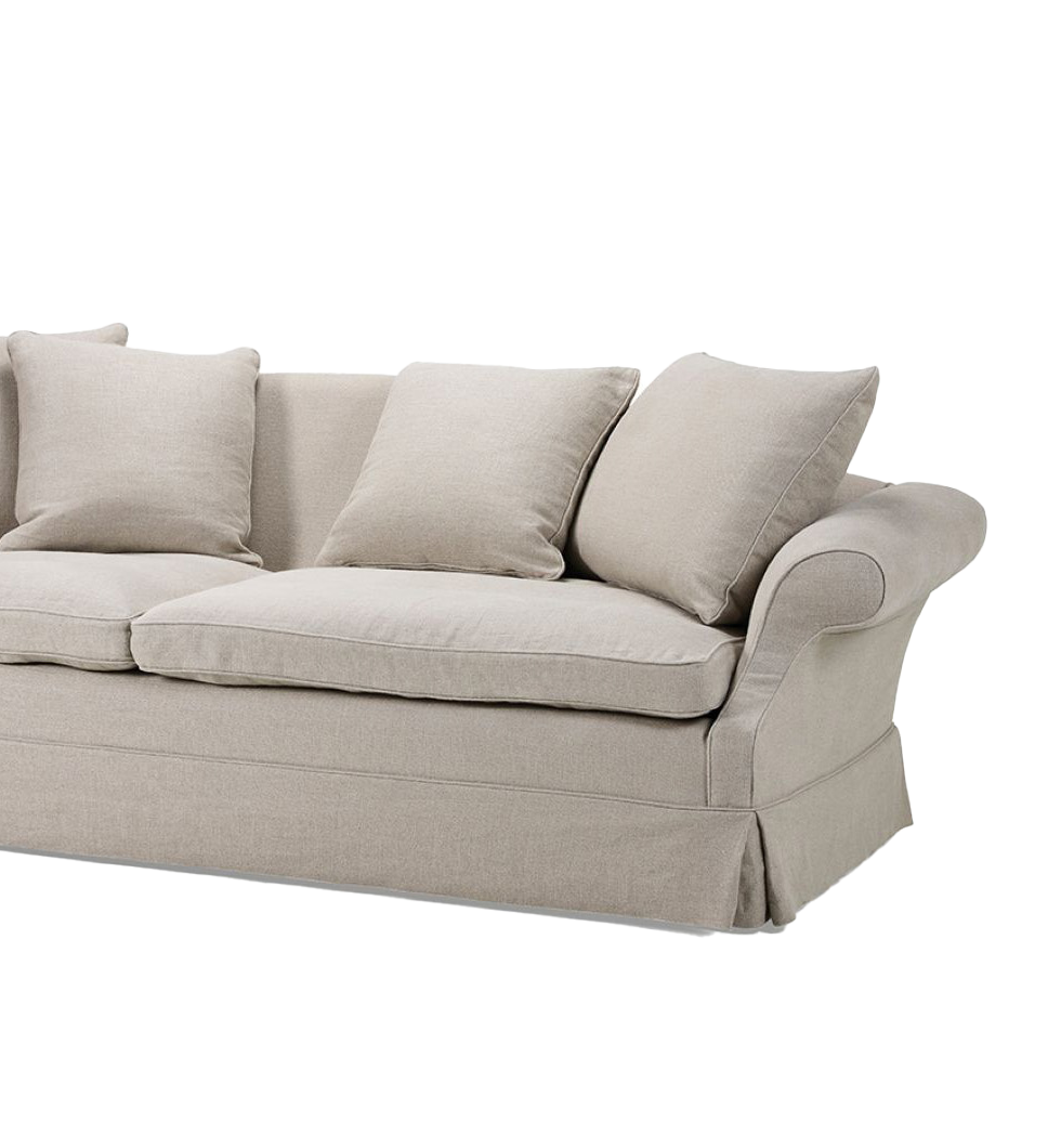 A light beige sofa with a low profile and soft cushions. The sofa features plush armrests, two large seat cushions, and three back cushions. The fabric is a soft linen-like material, and the base has a skirt with a gentle pleat detail.