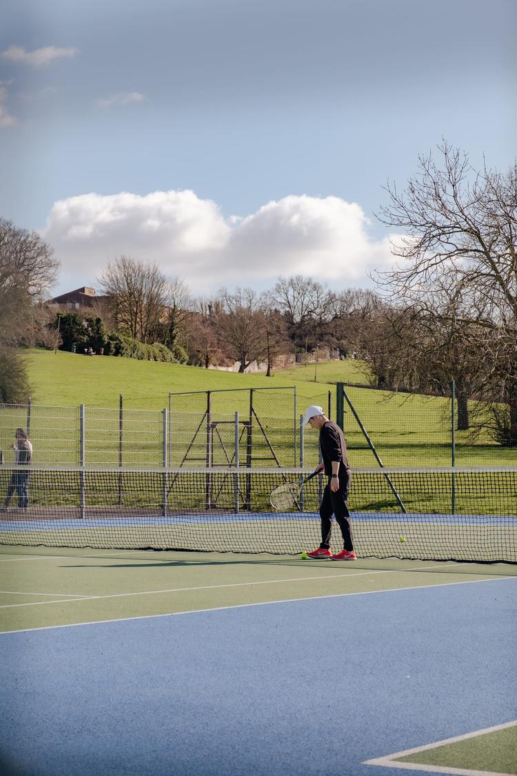 Man playing tennis at the Montrose Playing Fields, London