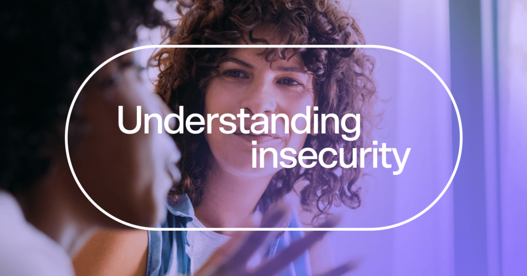 Woman is staring at another blurred person who is talking. Her facial expression is interested. She has curly hair. There is white text in an oval in the center of the screen that says understanding insecurity.