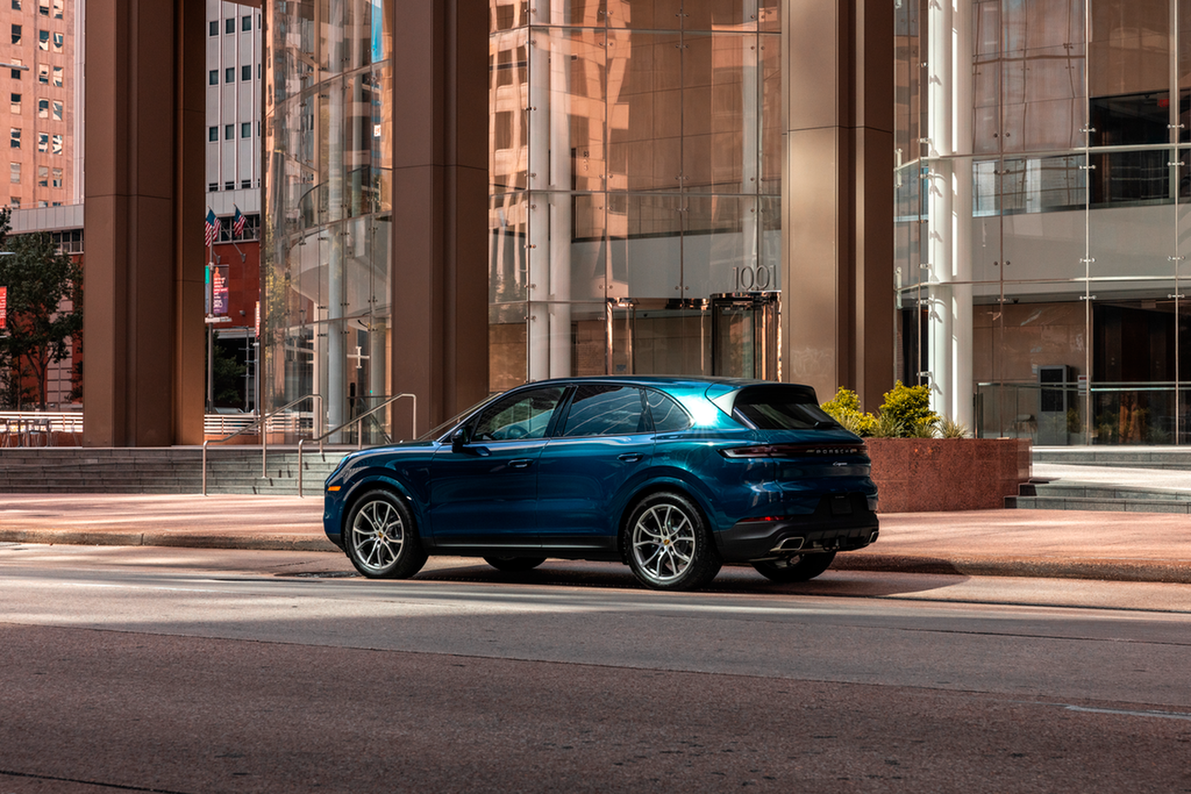 Blue Porsche Cayenne in a city plaza