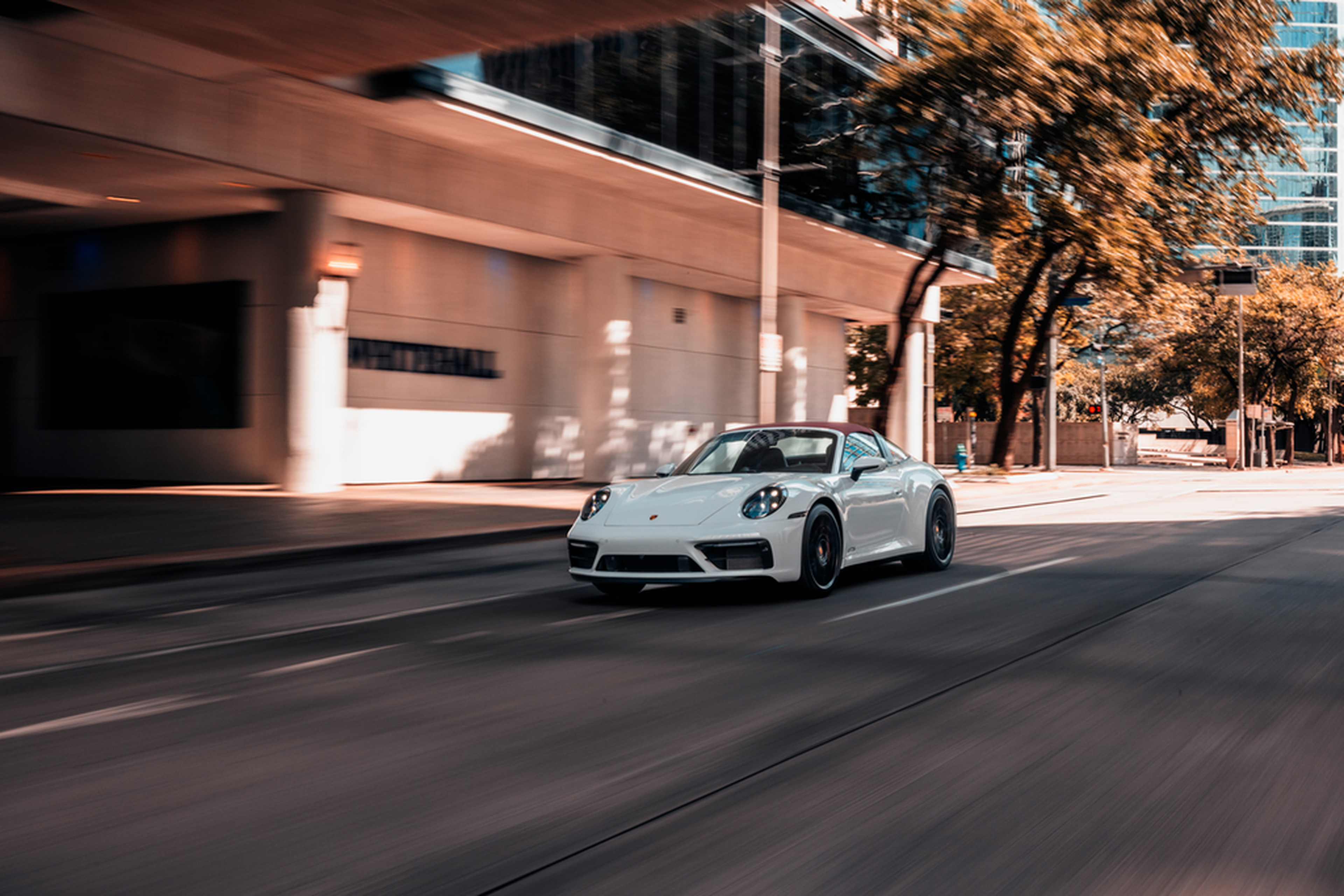 White Porsche 911 Targa driving downtown