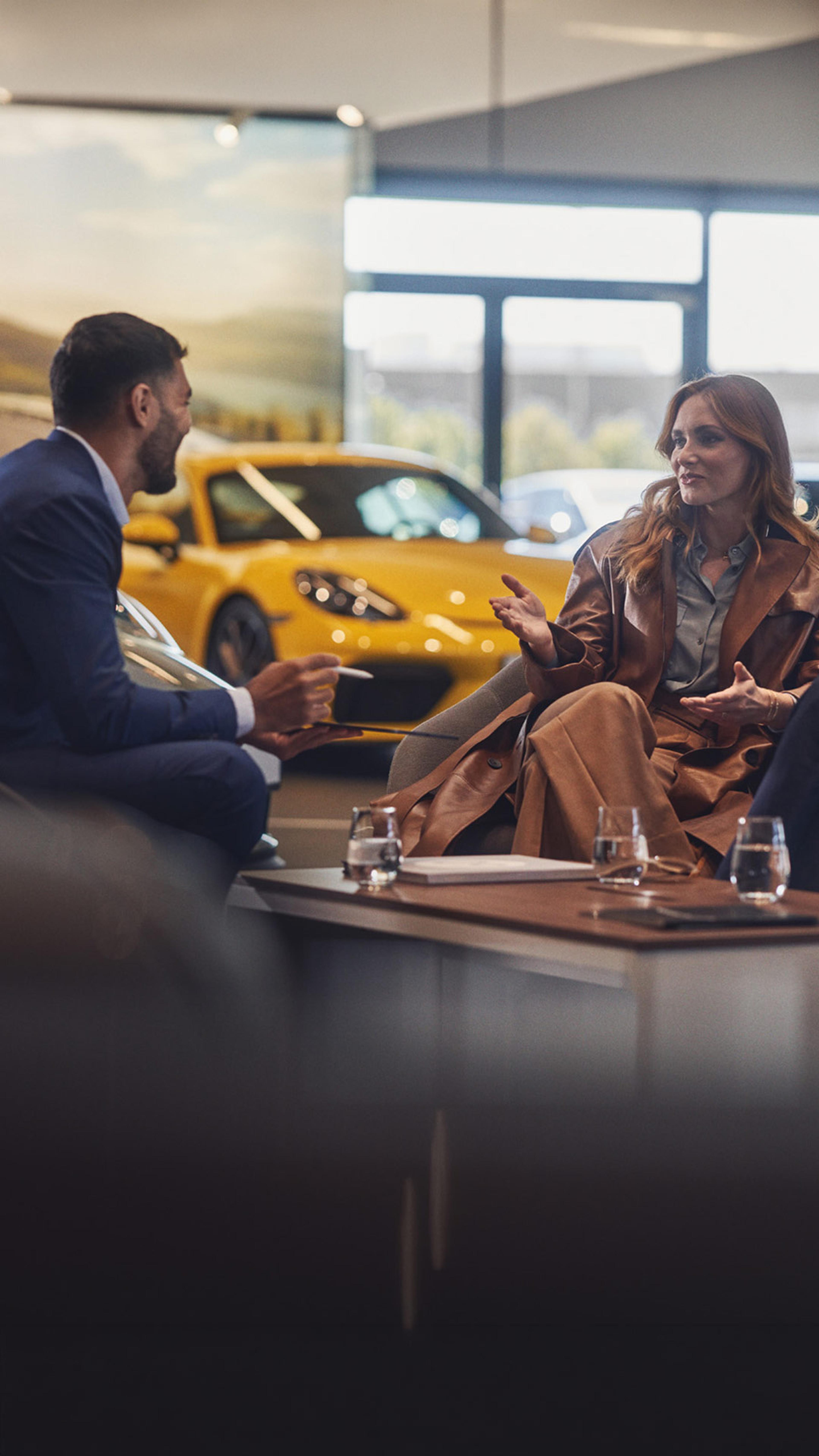 A couple discussing with a salesman in a car showroom