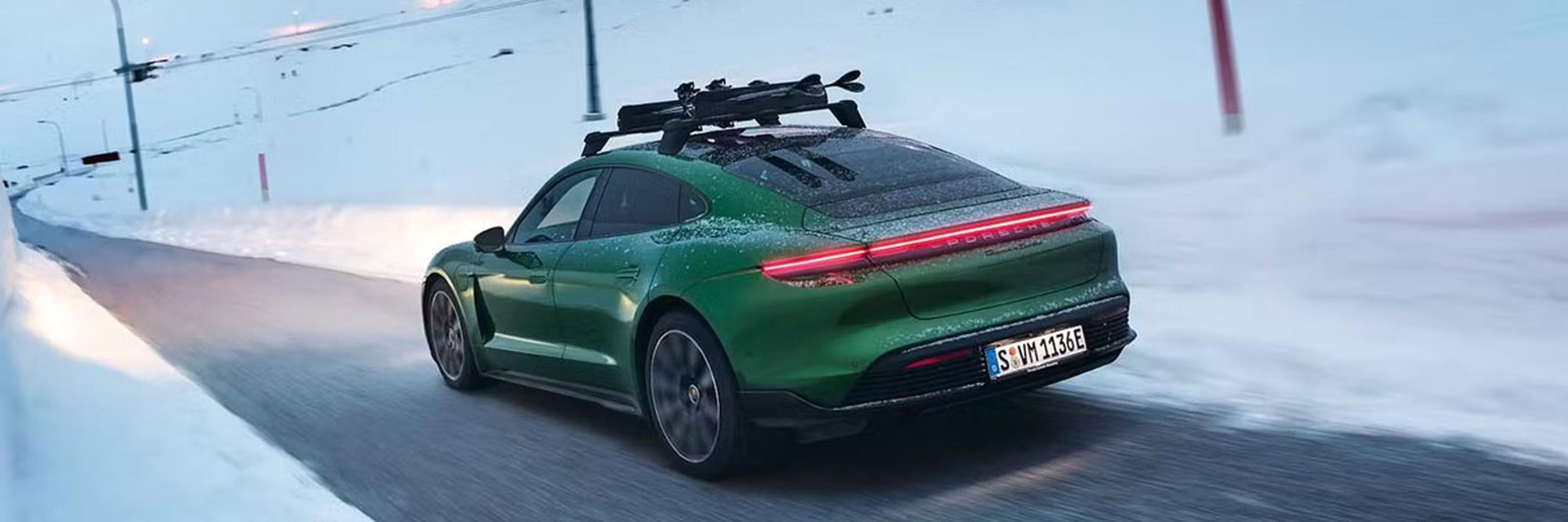 Green Porsche Taycan Driving On a Snowy Mountain Road
