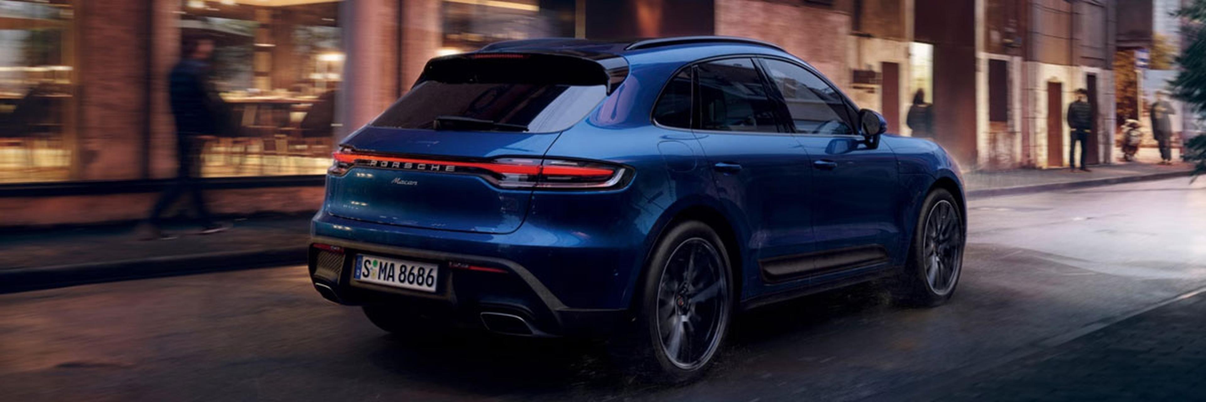 Blue 2026 Porsche Macan Driving Down Rainy Street