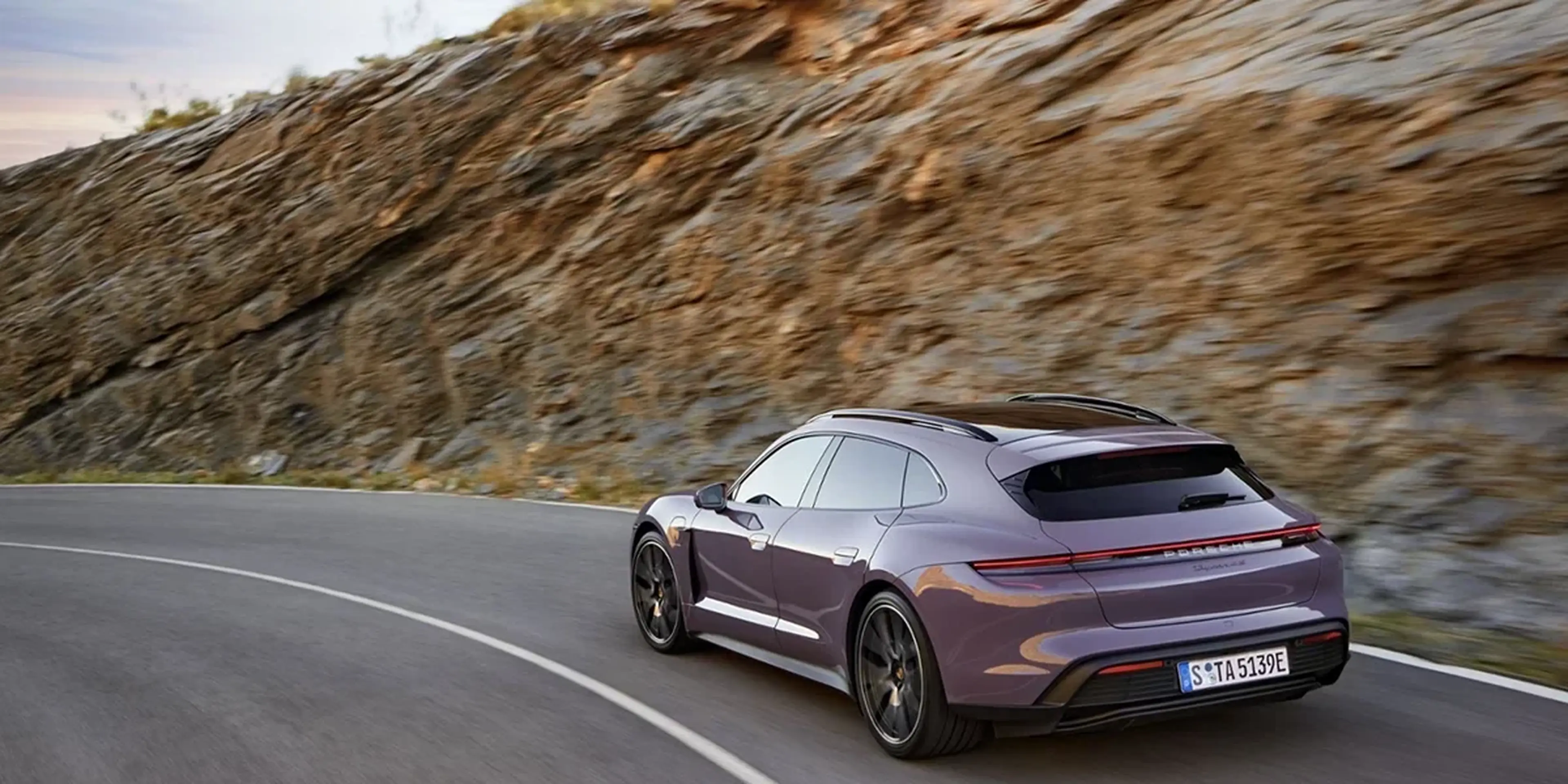 Purple 2025 Porsche Taycan Sport Turismo on a mountain road