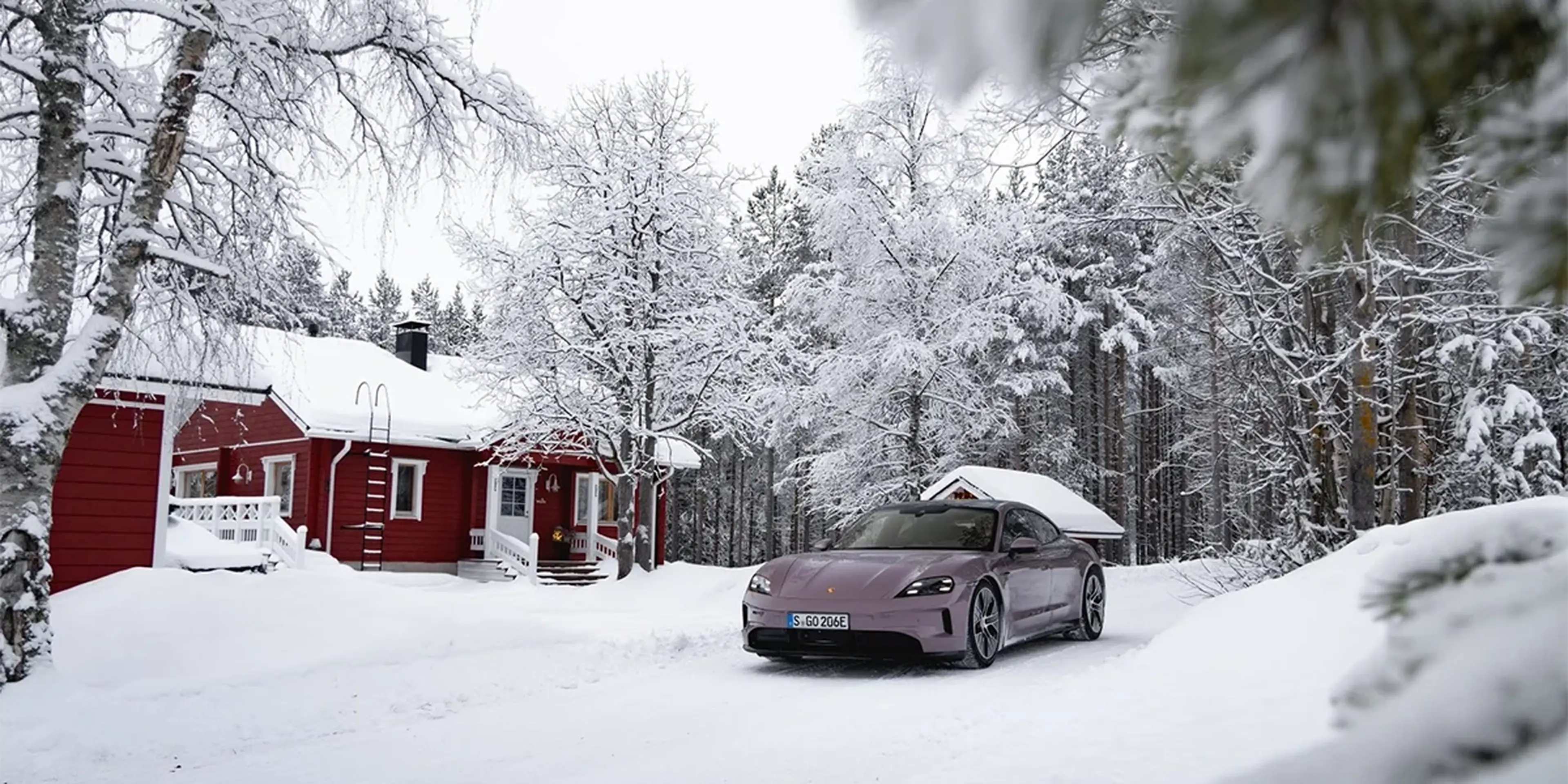 Overhead shot of Porsche Taycan with panoramic glass roof, contrasting with snow-covered terrain.