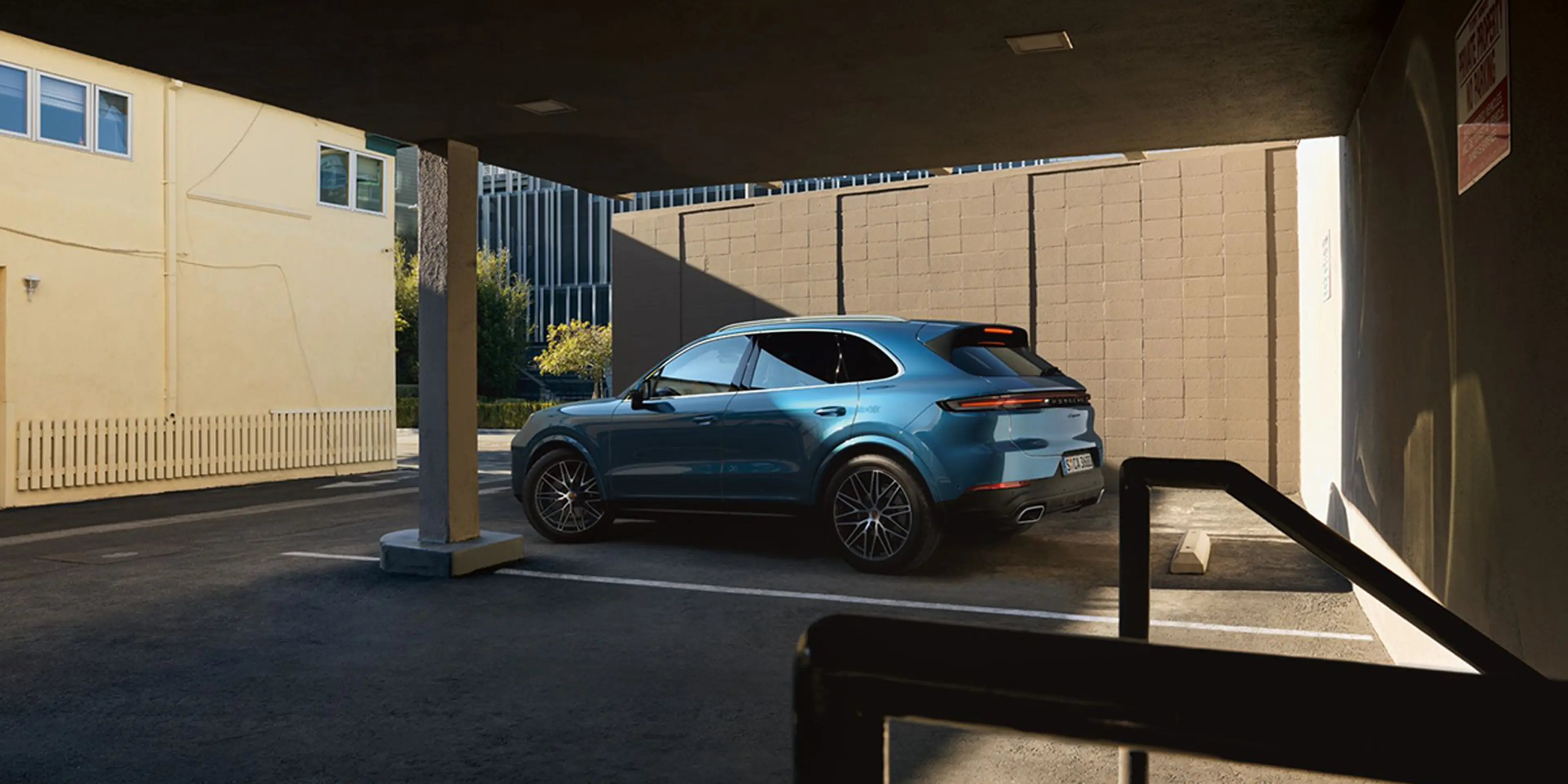 2025 Porsche Cayenne side view by a modern building