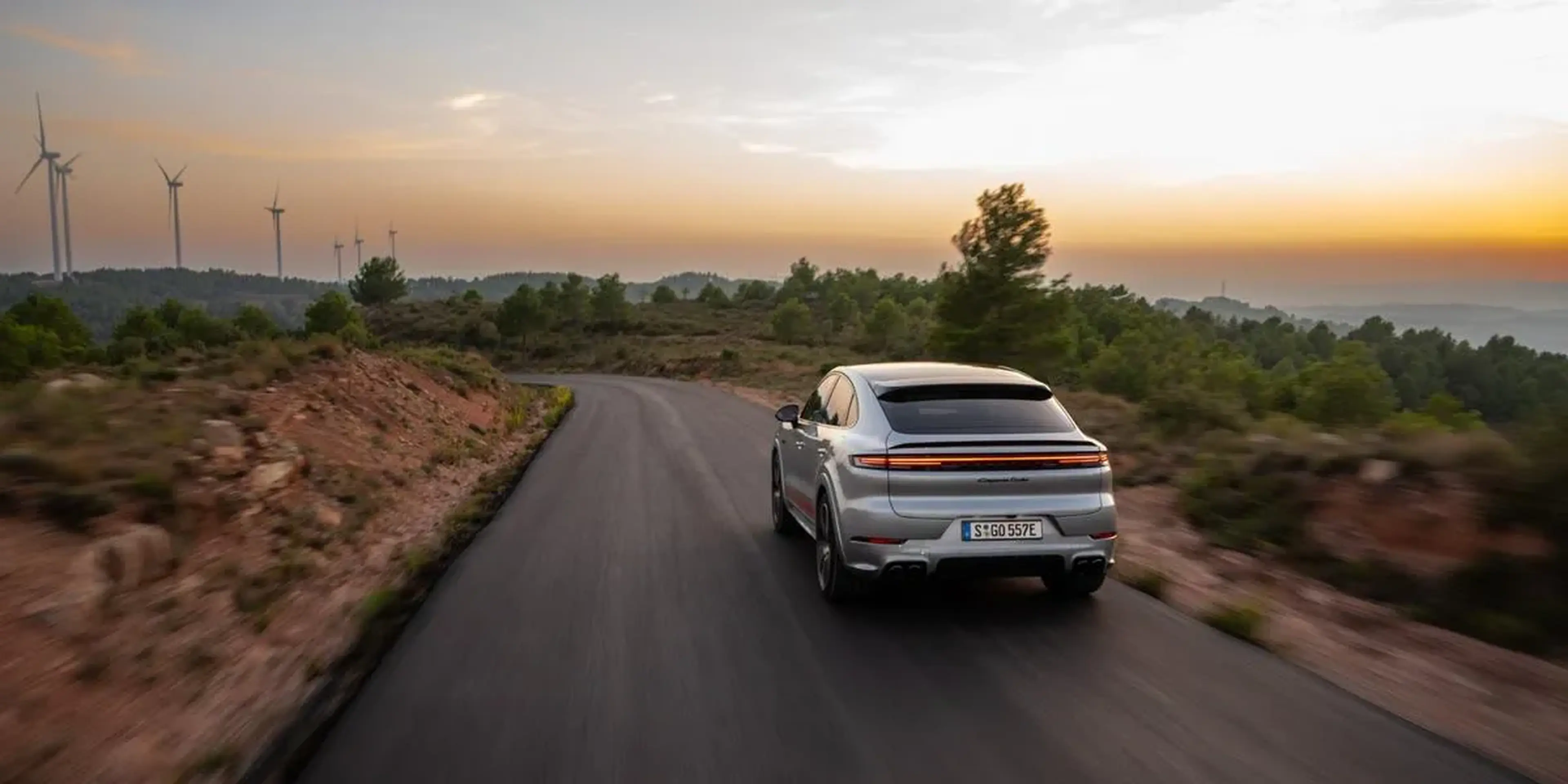 2026 Porsche Cayenne driving on an open road at dusk