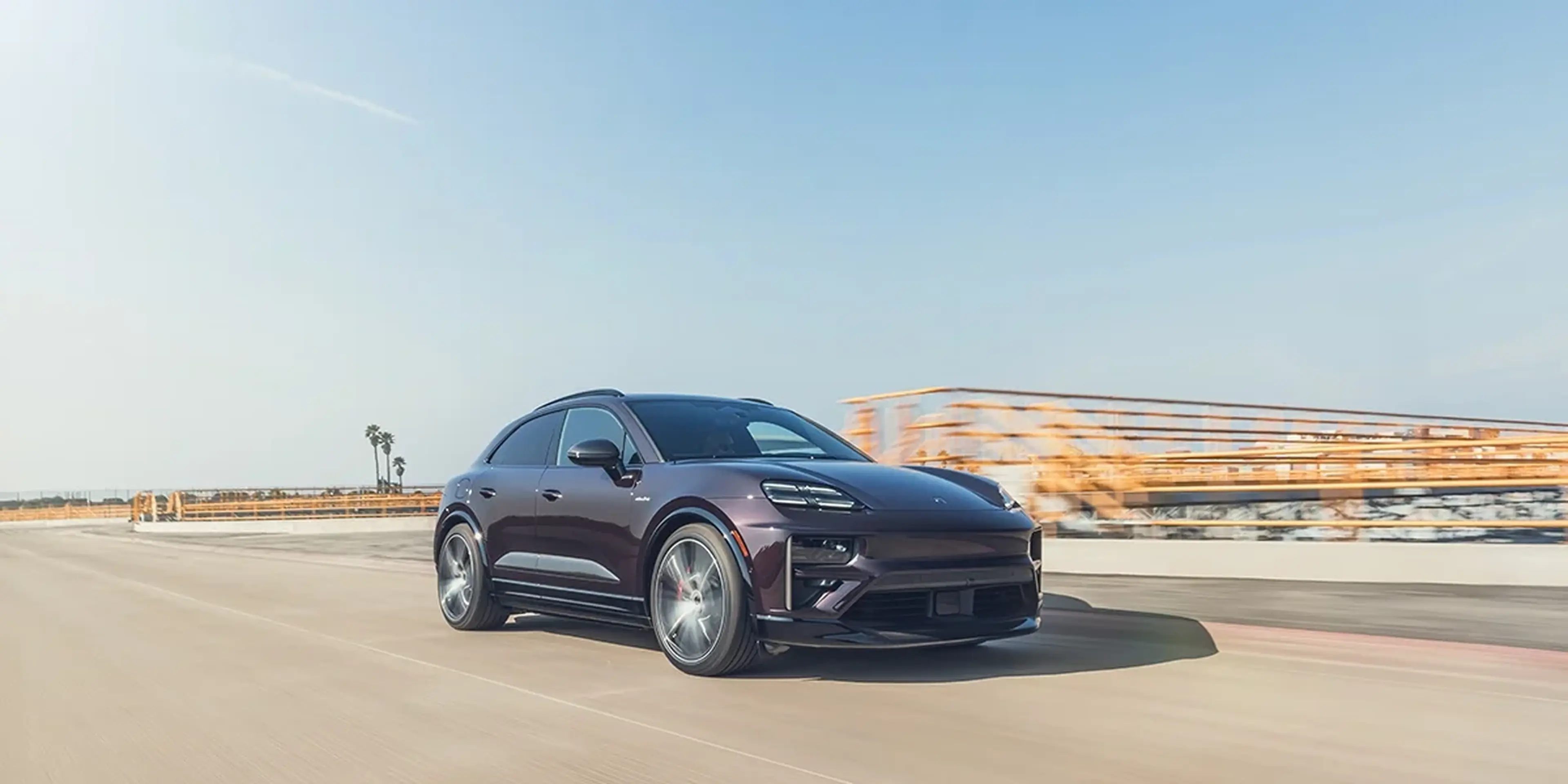 2025 Porsche Macan Turbo Electric driving on a sunny road