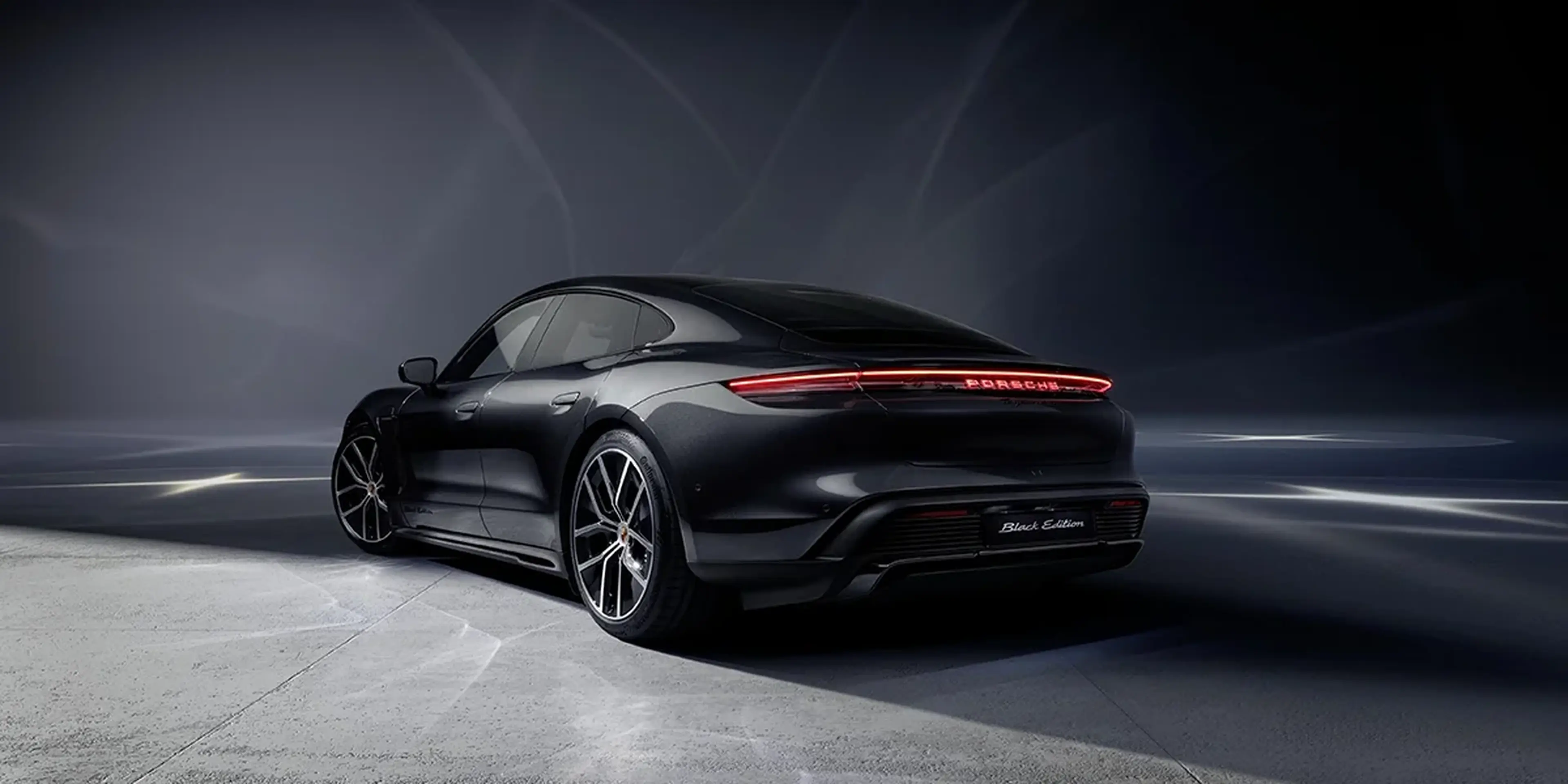 Overhead shot of Porsche Taycan with panoramic glass roof, contrasting with snow-covered terrain.
