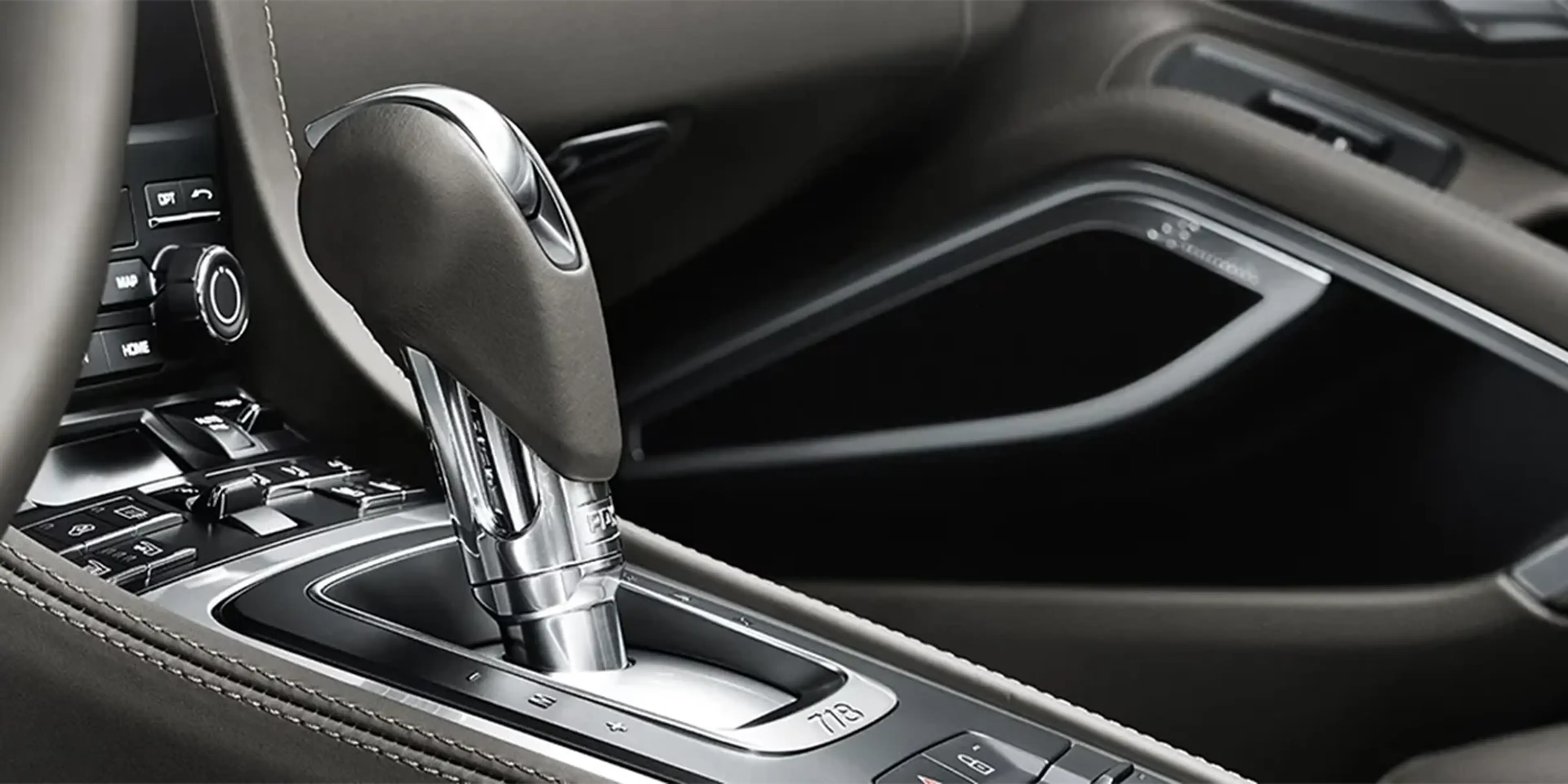 Porsche 718 Cayman driver-focused cockpit with sporty steering wheel, premium dashboard layout, and performance-centered controls.