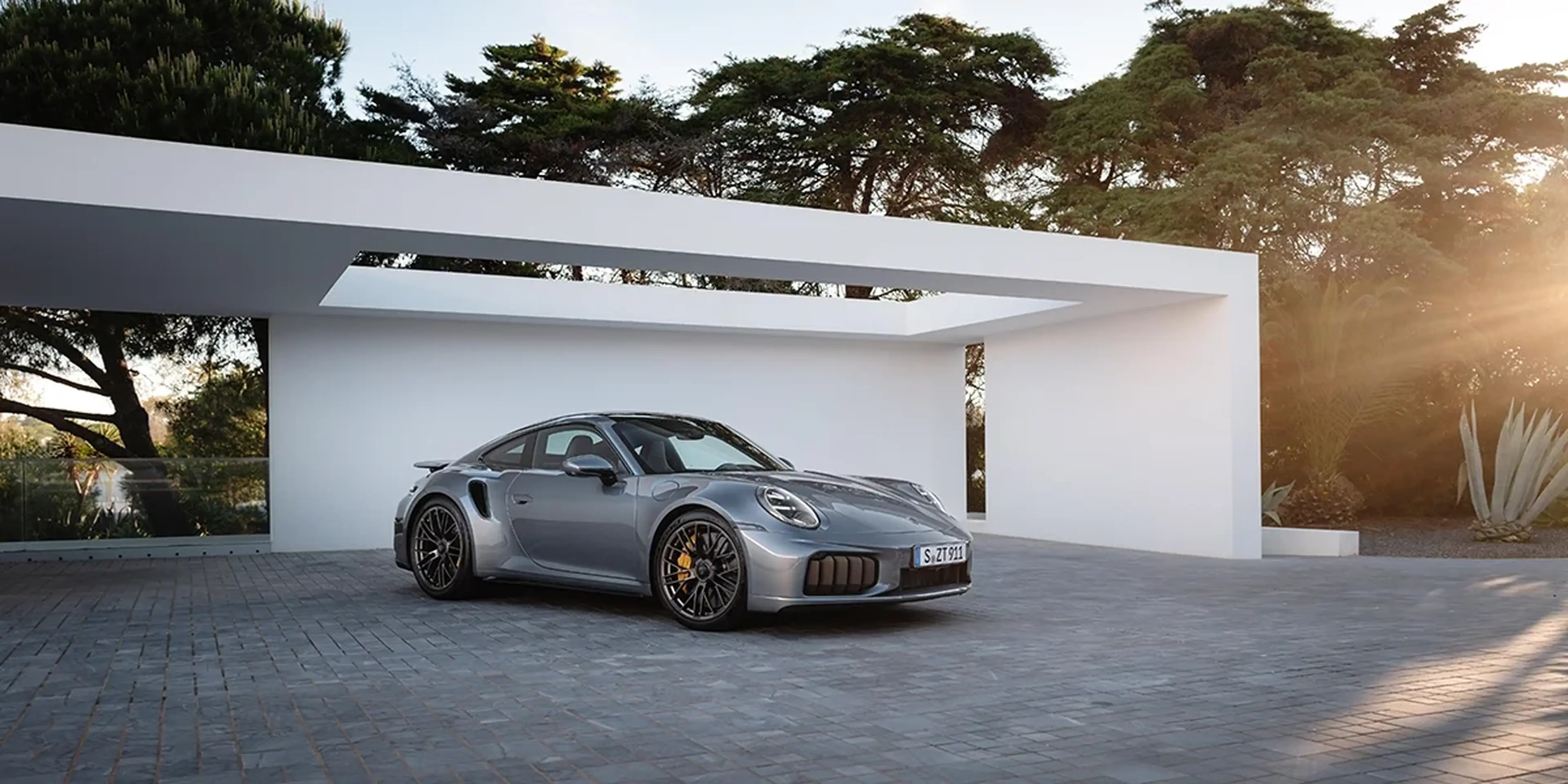 Gray 2026 Porsche 911 Turbo S outside a modern home