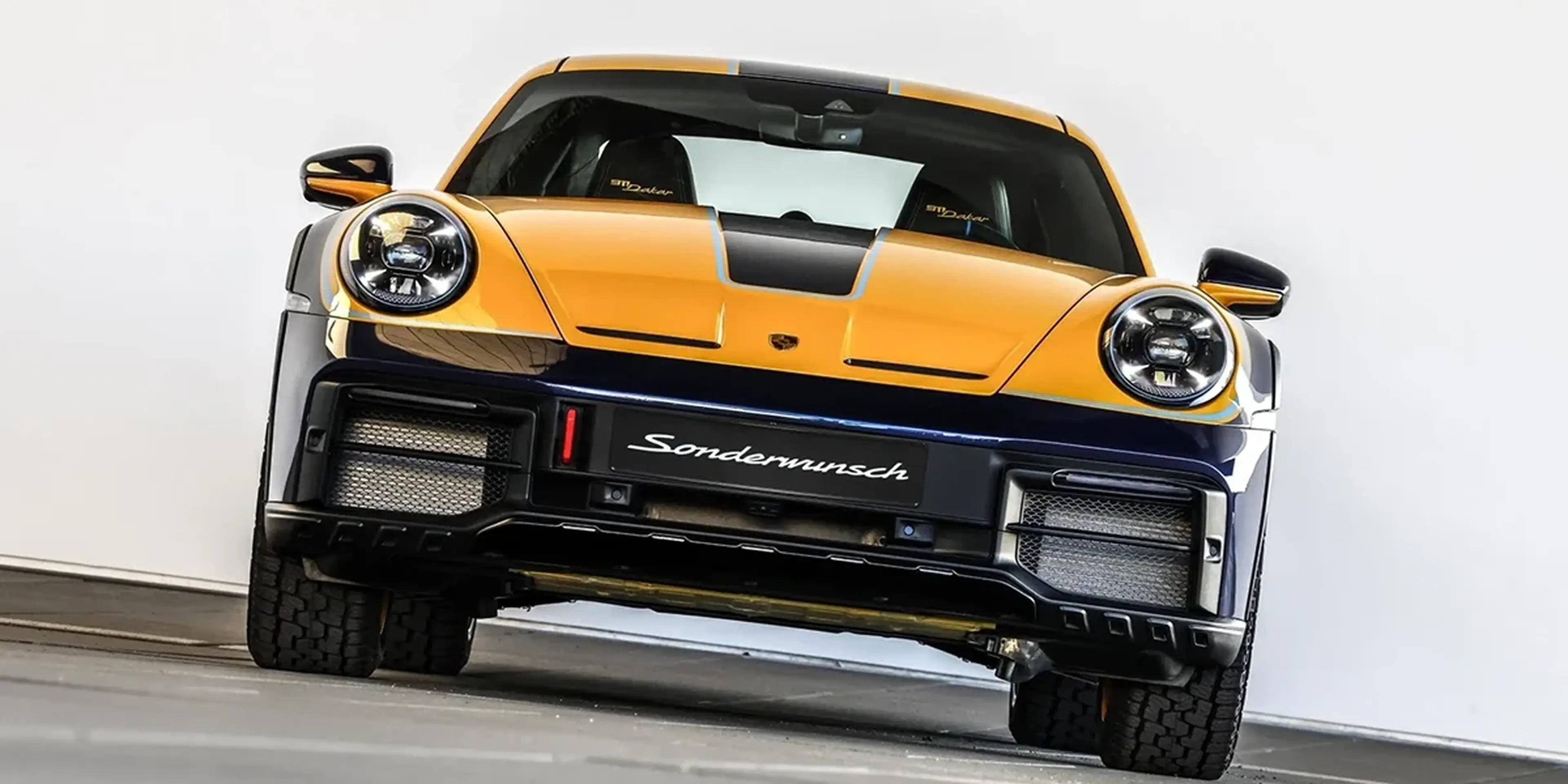 Front view of the Porsche 911 Dakar with lifted suspension, circular headlights, and off-road stance