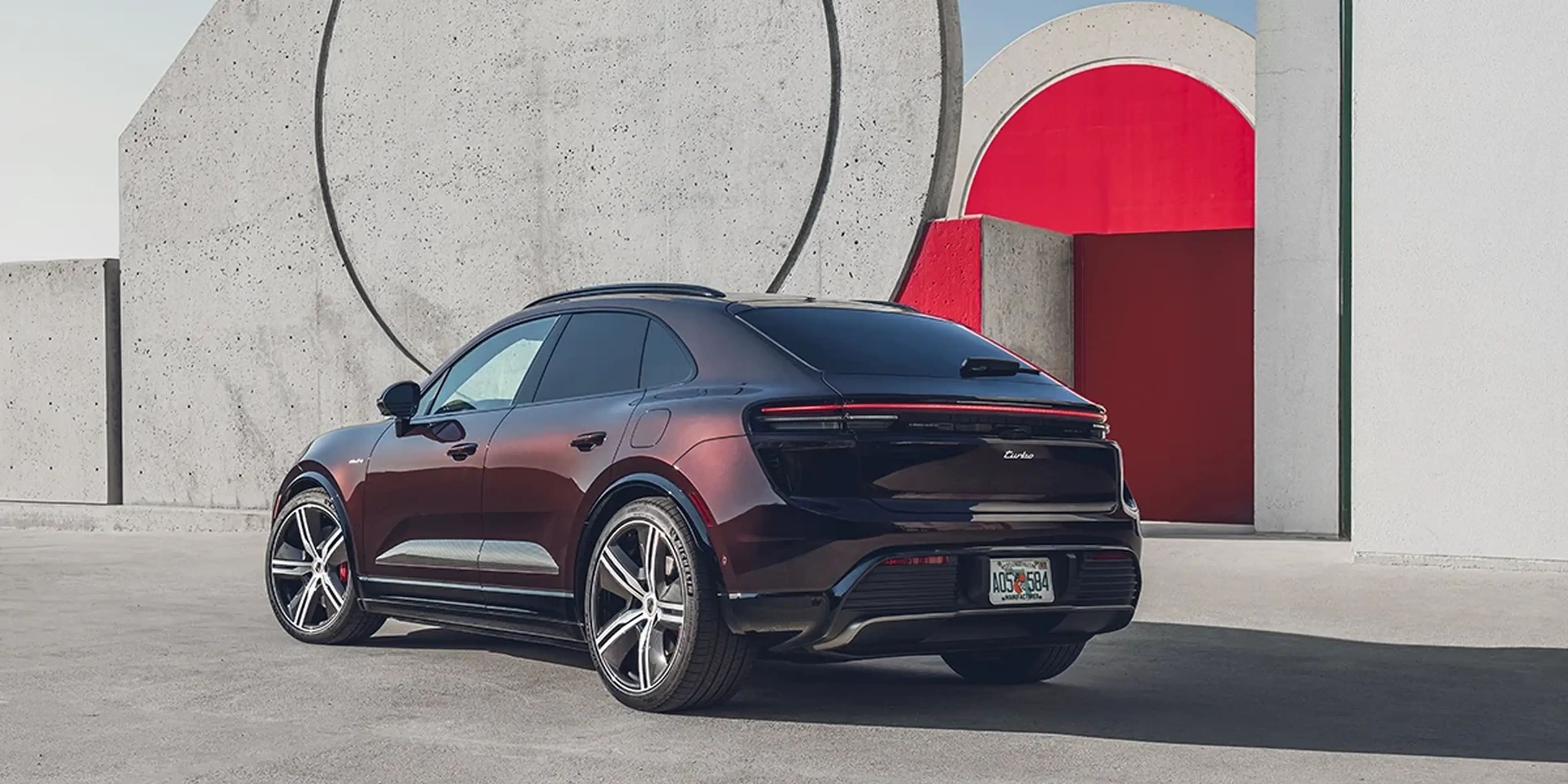 Burgundy 2025 Porsche Macan Turbo Electric rear three-quarter view