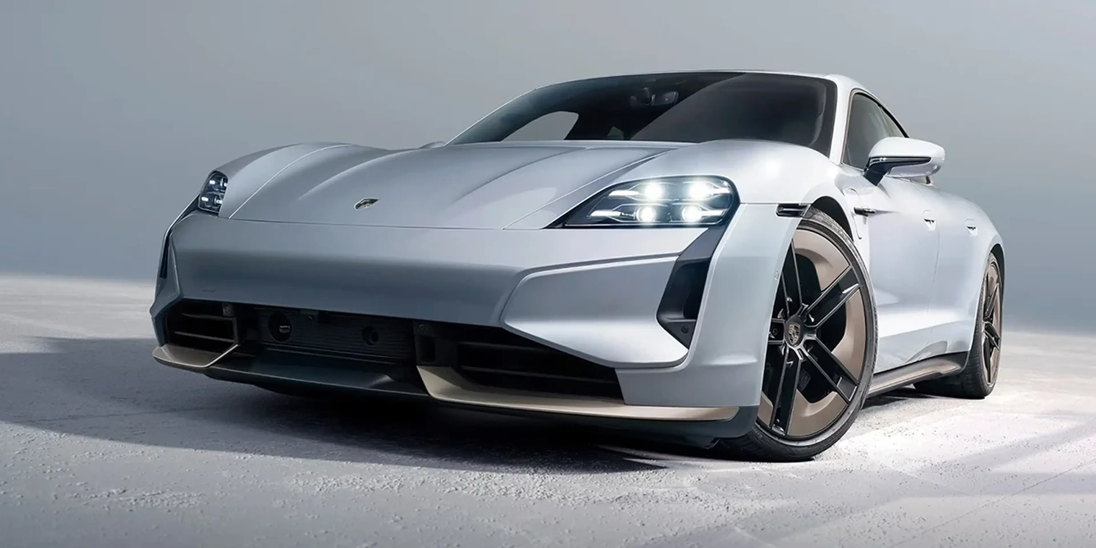 Porsche Taycan in silver, front three-quarter view with LED headlights.